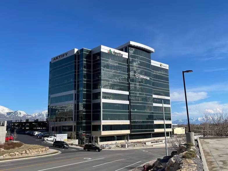 The Aktify office building in Utah, a glass office tower with the Aktify sign at the top left and mountains in the distance