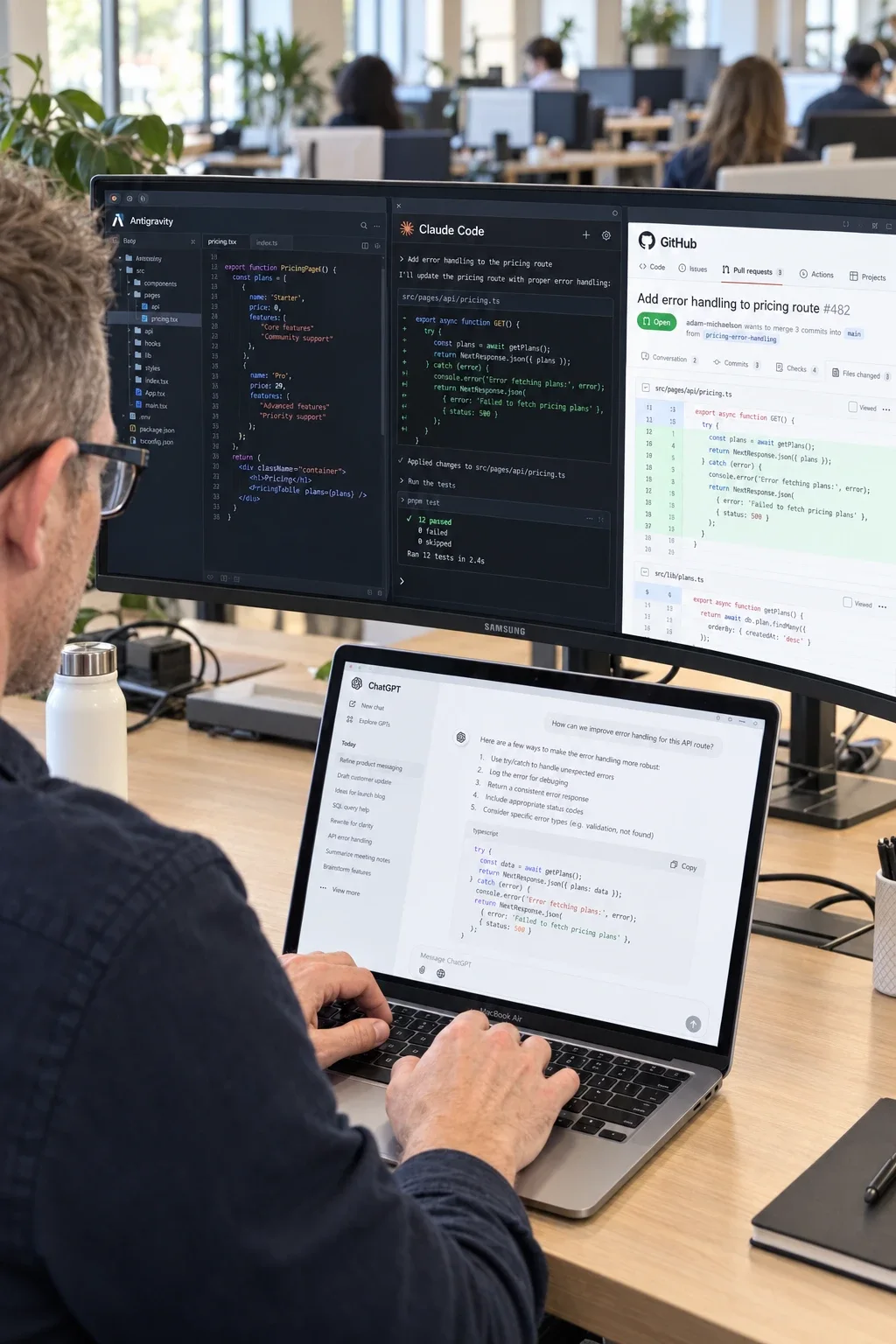 Over Adam Michaelson’s shoulder as he types on a MacBook Air showing ChatGPT, in front of a curved monitor showing Antigravity, Claude Code and a GitHub pull request, in an open coworking space