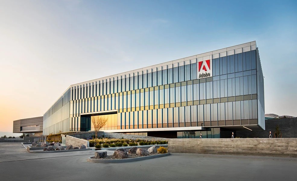 The Adobe Workfront office building in Utah at dusk, a long glass building with the Adobe sign on the upper corner